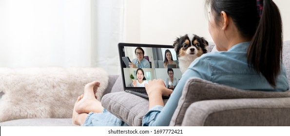 Banner of Asian woman on sofa and team on laptop screen talking and discussion in video conference and dog interruption.Working from home, Working remotely, Pets interruption and Self-isolation. - Powered by Shutterstock