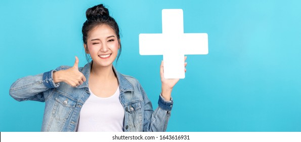 Banner of asian woman smiling, showing plus or add sign and thumb up on blue background. Cute asia girl wearing casual jeans shirt and showing join sign for increse and more benefit concept