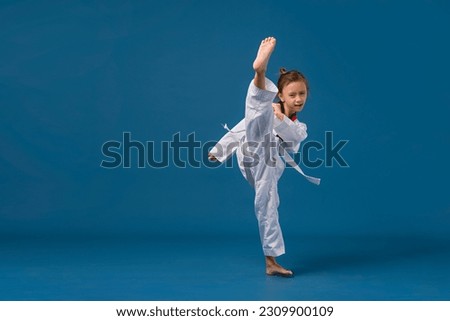 Banner: Asian-Australian girl poses in martial arts Practice taekwondo, karate, judo against a yellow background in the studio. Asian kids karate or Taekwondo martial arts. Sport kid training action.