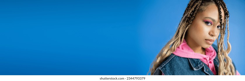 banner, beautiful african american woman with dreadlocks looking at camera on blue background - Powered by Shutterstock