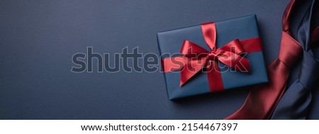 Banner with blue gift box and neckties on dark blue background. Father's day concept.