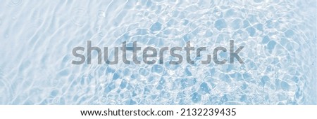 Banner of blue water, clean and transparent background, surface with vibrations from drops, flat lay