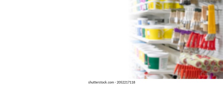 Banner Blurred Background Of The Shelves Of A Construction Store With Cans Of Paint And Rollers With Brushes. Abstract Blur White Background Of Store For Construction Home.