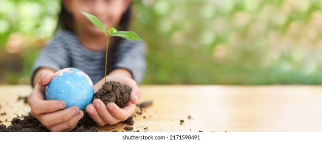 Banner of blurred  little girl is holding plant and globe model together, concept of ESG, environment, earth day, sustainability, world environment day, montessori education for kid and home school. - Shutterstock ID 2171598491