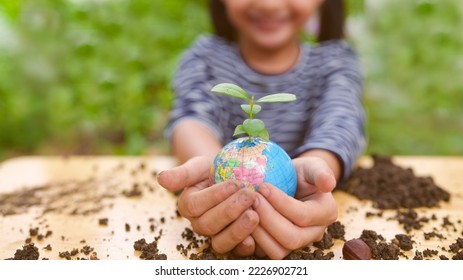 Banner of blurred  little girl is holding plant and globe model together, concept of ESG, environment, earth day, sustainability, world environment day, montessori education for kid and home school. - Powered by Shutterstock