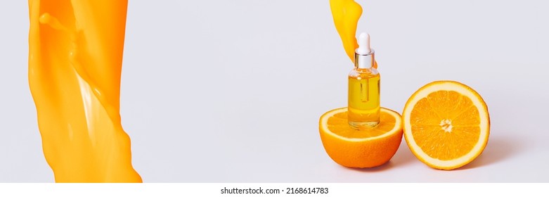 Banner Bright Orange Liquid Pours Beautifully On A Bottle Of Aromatic Body Oil And Orange Halves On A White Background. Natural Cosmetics, Anti-aging Antioxidant Cosmetic Vitamin C Serum.