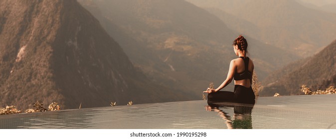 Banner Calm of Athletic Asian woman practice yoga Lotus pose on the pool in the morning in front of beautiful nature views,Healthy woman breathing and meditation yoga comfortable and relax,Warm tone