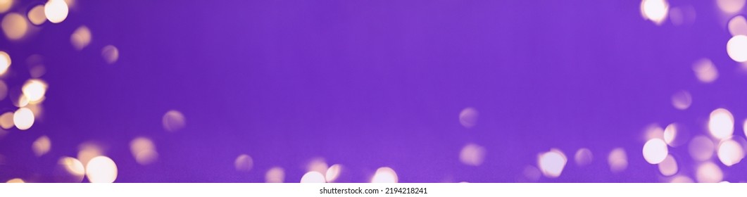 Banner Of Christmas Bright Gold Colors Bokeh Different Sizes Around The Frame On Vibrant Purple Blurred Background. Holiday Template And Shiny Greeting Concept With Copy Space.