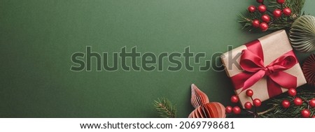 Banner with Christmas gift and decorations on olive background.