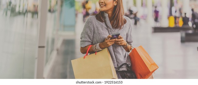 Banner Cover Of Asian Woman Using The Smart Mobile Phone For Check Online Shopping Order With Clothes Beside The Glassess In Store Shop At Department Center,shopaholic And Fashion Concept