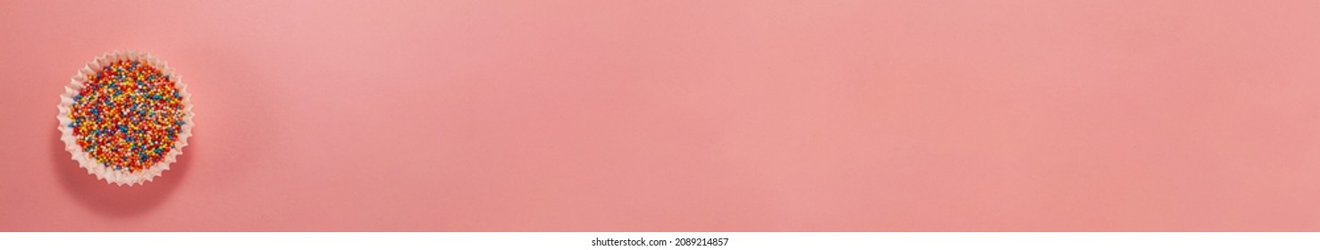 Banner Of Cupcake Liners With Colored Sugar Inside From Above. Flat Lay Top View. Confectionery Cooking Concept On Bright Pink Paper Background. National Cooking Day