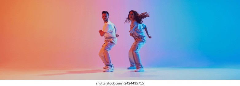 Banner. Dance duo dancing hip hop in motion against gradient t studio background with negative space to insert your text. Concept of movement, energy, dance battles. Dynamic gel portrait - Powered by Shutterstock