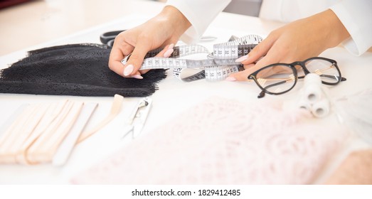 Banner of designer clothes and lingerie made of pink and black lace, close-up of a measuring tape.