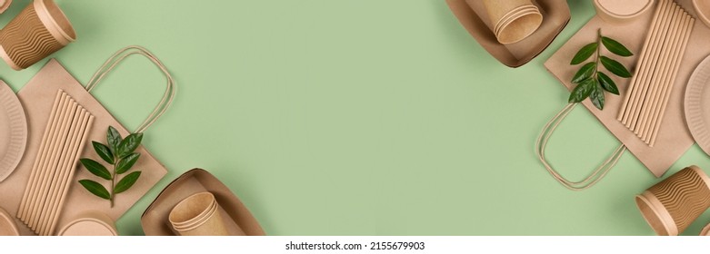 Banner with eco-friendly tableware - kraft paper food packaging on light green background with copy space. Street food paper packaging, recyclable paperware, zero waste packaging concept. Flat lay