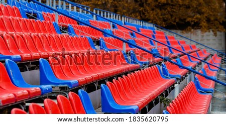 Banner. Empty seats in the stands of the arena or auditorium. Rows of red and white stadium seats without spectators. The concept of the abolition of sports and mass entertainment events.