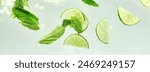 Banner. Essence of summer. Lime slices and mint leaves adding cool and flavorful twist to glass of water. Textured photo. Abstract wallpaper. Concept of nutrition, healthy, detox, refreshing. Ad