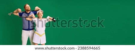 Banner. Father and daughter on golf court. Dad, man and girl, teenager dressed like golf players posing with golf clubs on green background. Concept of parenthood, hobby, recreation, active lifestyle.