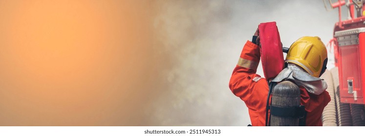 Banner Firefighter Rescue team training in fire fighting. Panorama Teamwork Firefighter fighting flame using fire hose chemical water foam spray. Fireman teams safety uniform hard hat with copy space - Powered by Shutterstock