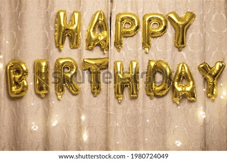 A banner of foil balloons saying : Happy Birthday