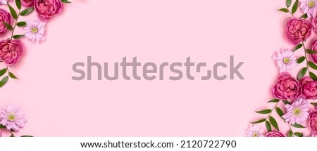 Banner with frame made of rose flowers and green leaves on a pink background. Springtime composition with copyspace.