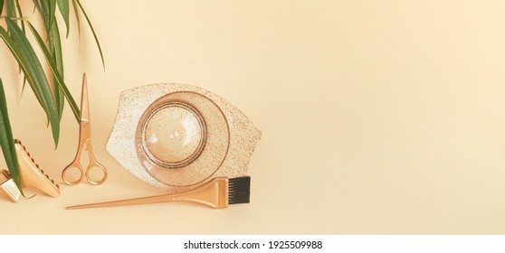 Banner with gold hairdressing tools, plant leaves on a yellow background. Scissors, clip, brush and bowl for dyeing hair in warm sunlight. Template with space for text. - Powered by Shutterstock