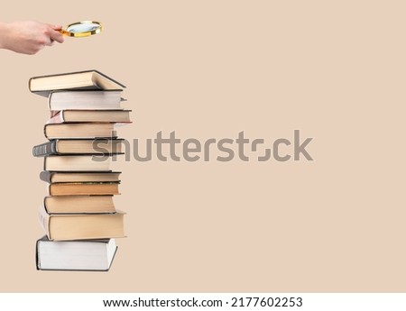 Banner with hand holding magnifying glass over books stack. Information search and analysis, research conducting. Data study for preparing for exams. Student lifestyle concept. Copy space. photo