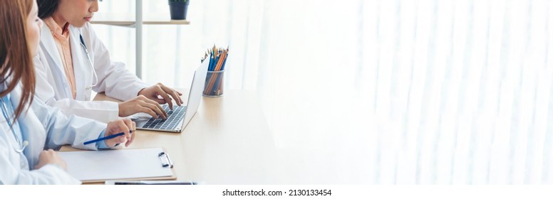 Banner Hands Of Two Women Doctor Medical Lab Discussing Together Healthcare Teamwork. Panorama Two Asian Women Doctors Meeting Write Prescription Medical Clinic Office Using Laptop With Copy Space.