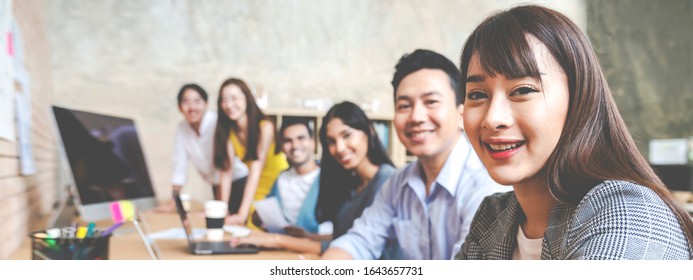 Banner Of Happy Creative Team Are Smiling And Looking At Camera In Modern Workspace Office. Happy Group Of Confident Employee In Cowork. Relation And Engagement Concept.