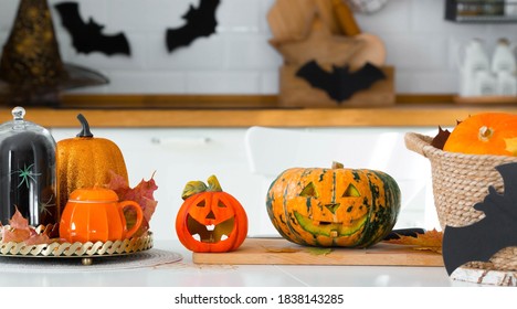 Banner. Happy Halloween! Pumpkin Jack on the table. Lantern with a carved smile and different attributes of the holiday on a light background in the interior. For family holidays at home. Copyspace.