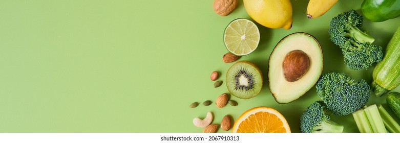Banner of healthy and nutritious vegetables, fruits and nuts on light green background, copy space. Avocado, broccoli lime, kiwi almond, celery lemon, orange and banana, cucumber cabbage - Powered by Shutterstock