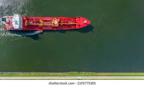 Banner Of Industrial Fuel And Petrochemical Tanker Being Led By The Pilot Boat. Piloting Service. Unknown Waters. Banner Top View Of German Pilot Boat With Tanker By Changing Of Marine Pilot.