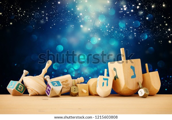 Banner of jewish holiday Hanukkah with wooden dreidels (spinning top) over glitter shiny background