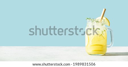 Banner. Lemonade on blue background close up. Summer drinks and vacation concept. Sunny day shadows, copy space