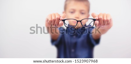 Banner little boy with glasses correcting myopia close-up portrait. Ophthalmology problem. Selective focus