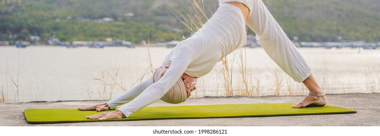 BANNER, LONG FORMAT Kundalini Yoga Woman In White Clothes And Turban Practices Yoga Kundalini On The Background Of The Sea, Mountains And Sunset. Fighting Face Painting Of The Indians Shows Her Inner