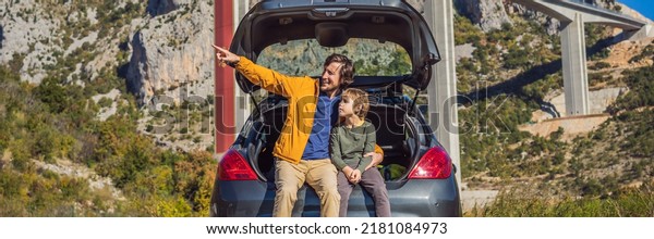 BANNER, LONG FORMAT Montenegro. Dad and son\
tourists are sitting on the trunk of a car. Road trip around\
Montenegro. Bridge Moracica. Reinforced concrete bridge across the\
Moraci gorge. The\
motorway