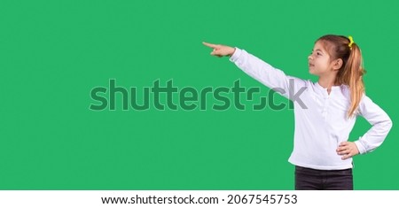Banner, long format. Side space photo of a schoolgirl wearing school uniform turned her head to the side with one hand pointing using index finger to the side and the other hand keeping on her belt.