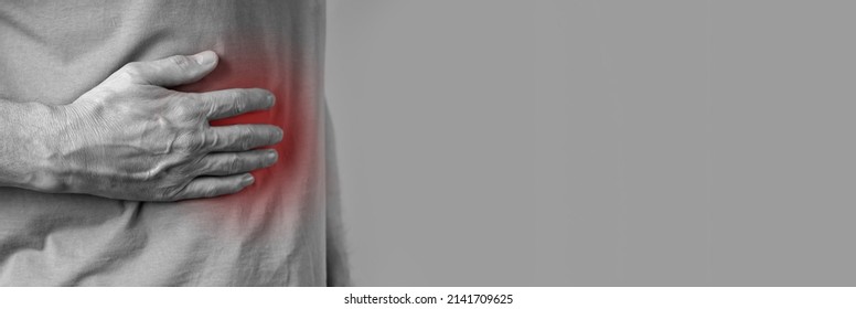 Banner With Man Suffering From Liver Pain. Hand Holding Abdomen Right Side With Red Point Closeup. Diseases, Alcohol Abuse, Organ Inflammation, Injuries. Copyspace. High Quality Photo