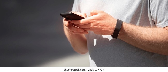 Banner of a man  using a smartphone while waiting at a train station platform, copy space