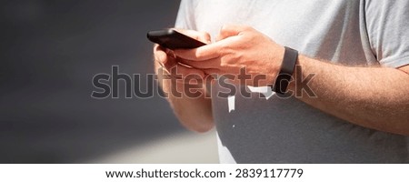 Banner of a man  using a smartphone while waiting at a train station platform, copy space
