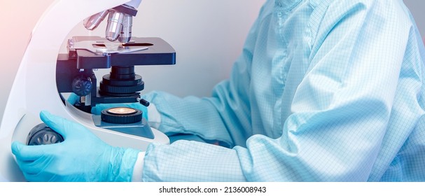Banner microscope with metal lens at laboratory with hand of pharmacology worker. Concept industry lab.
