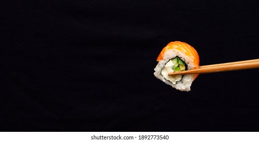 Banner with one sushi roll on black background with large copy space - Powered by Shutterstock