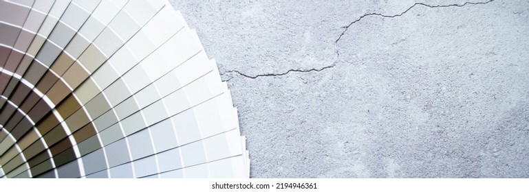 Стоковая фотография: Banner paint samples colors swatch for interior design. Gray concrete background, earth tone colors.