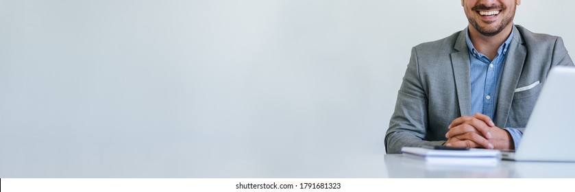 Banner panorama of faceless mid body section young smiling cheerful businessman entrepreneur in bright white modern office facing towards camera copy space for text