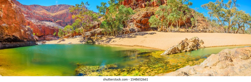 Banner Panorama Of Ormiston Gorge Water Hole With Ghost Gum In West MacDonnell Ranges, Northern Territory, Australia. Ormiston Gorge Is A Great Place To Swim Or See The High Walls Of Gorge And Pound.