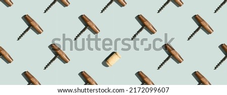 Banner. Pattern with corkscrews and wine bottle cork on blue background with hard light and shadow at sunlight. Repeat pattern top view, flat lay