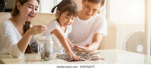 Banner Photo Of Asian Family Teach Their Daughter To Saving Money And Putting Coins Into Glass Bank Spend A Quality Time Together. Asian Family, Relationship, Happiness And Investment Concept