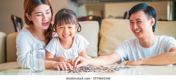 Banner Photo Of Asian Family Teach Their Daughter To Saving Money And Putting Coins Into Glass Bank Spend A Quality Time Together. Asian Family, Relationship, Happiness And Investment Concept