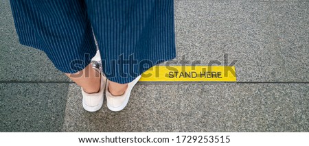 Banner photo of Asian woman standing on social distancing sign for keep distance and queue for entrance subway train a new normal life trend. corona virus, social distancing or new normal concepts
