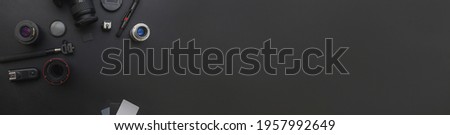 Banner. Photographer work place with dslr camera system, camera cleaning kit, lens and camera accessory on dark black table background. Hobby travel photography concept. Flat lay top view copy space
